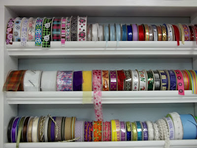 Awesome ribbon storage idea at craftaholicsanonymous.net! Come see all the storage ideas in this craft room tour. moulding ribbon storage