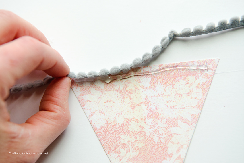 Use pom pom trim and hot glue to make Paper pennant banners. Super cute and so easy!