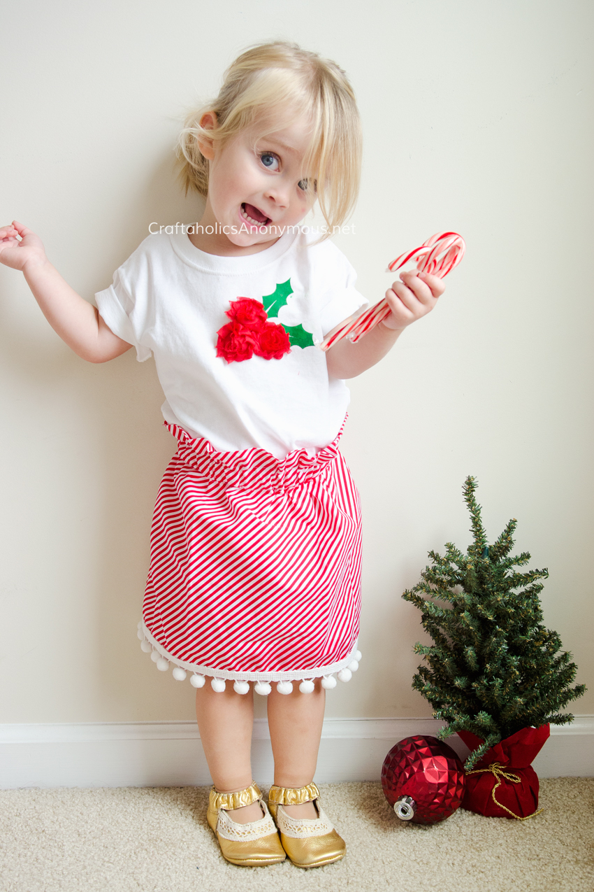 DIY Christmas outfit for girls. Holly Berry Shirt with Candy Cane stripe Skirt with Pom poms. Easy to make and ADORABLE! www.craftaholicsanonymous.net