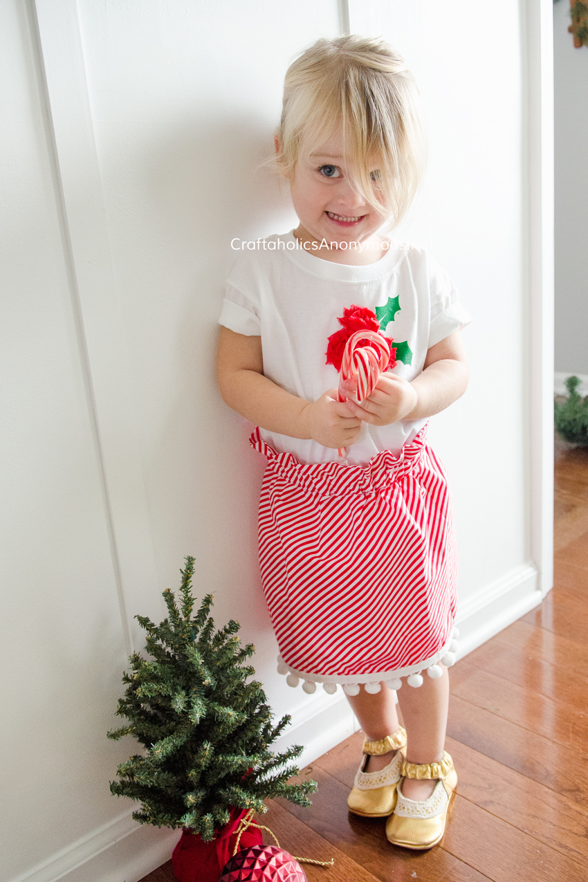 DIY Candy Cane Christmas skirt with paper bag waist and pompom trim. So adorable!! Whips up in about 1 hour. Free Easy sewing pattern! www.CraftaholicsAnonymous.net